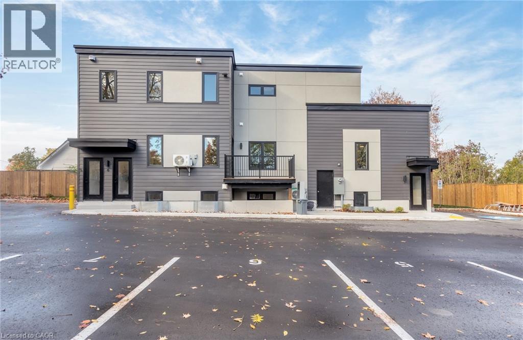 A modern two-story building with a parking lot in front.