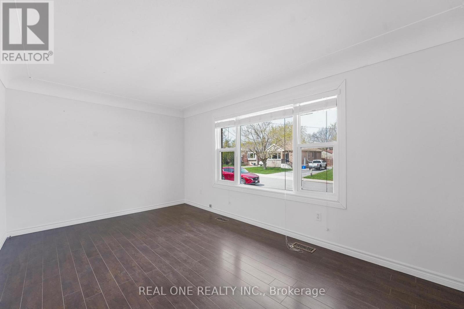 A room with a large window showing a street view.