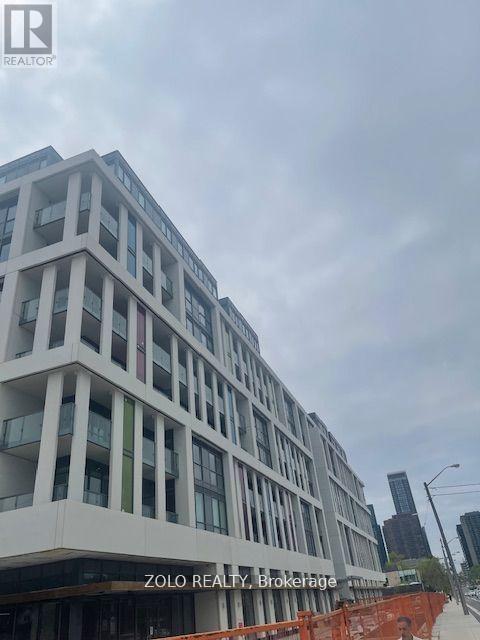 A modern building with the sign ZOLO REALTY, Brokerage in front of it.