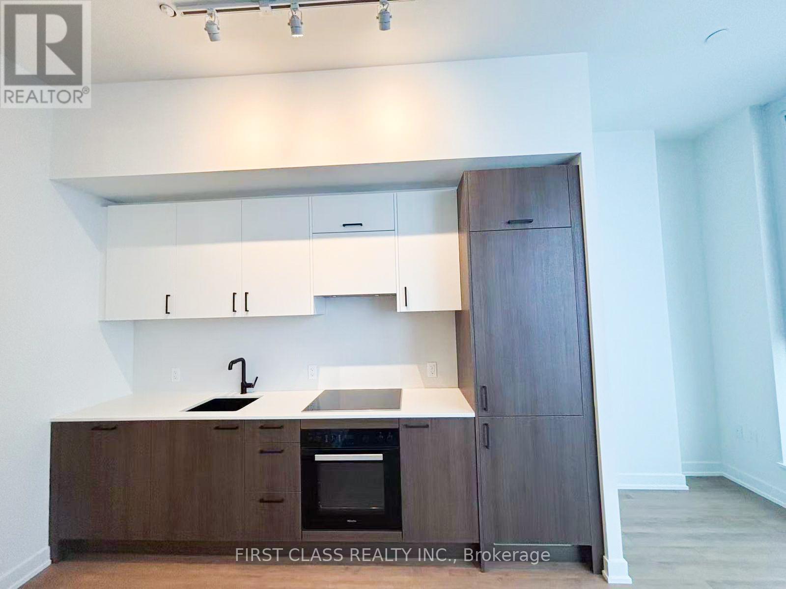 A kitchen with wooden cabinets and a black oven.