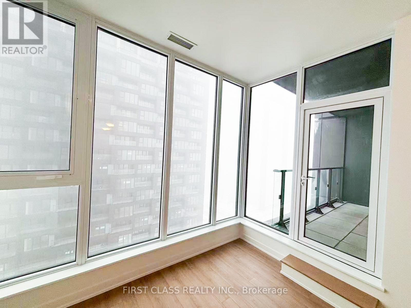 A room with a view of a cityscape through large windows.