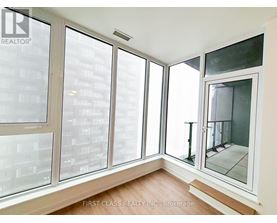 A room with a view of a cityscape through large windows.