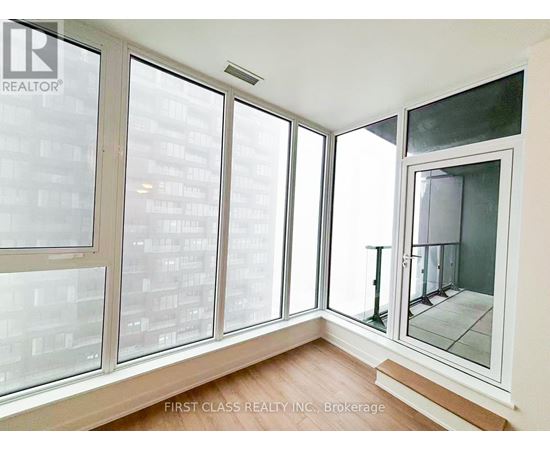 A room with a view of a cityscape through large windows.
