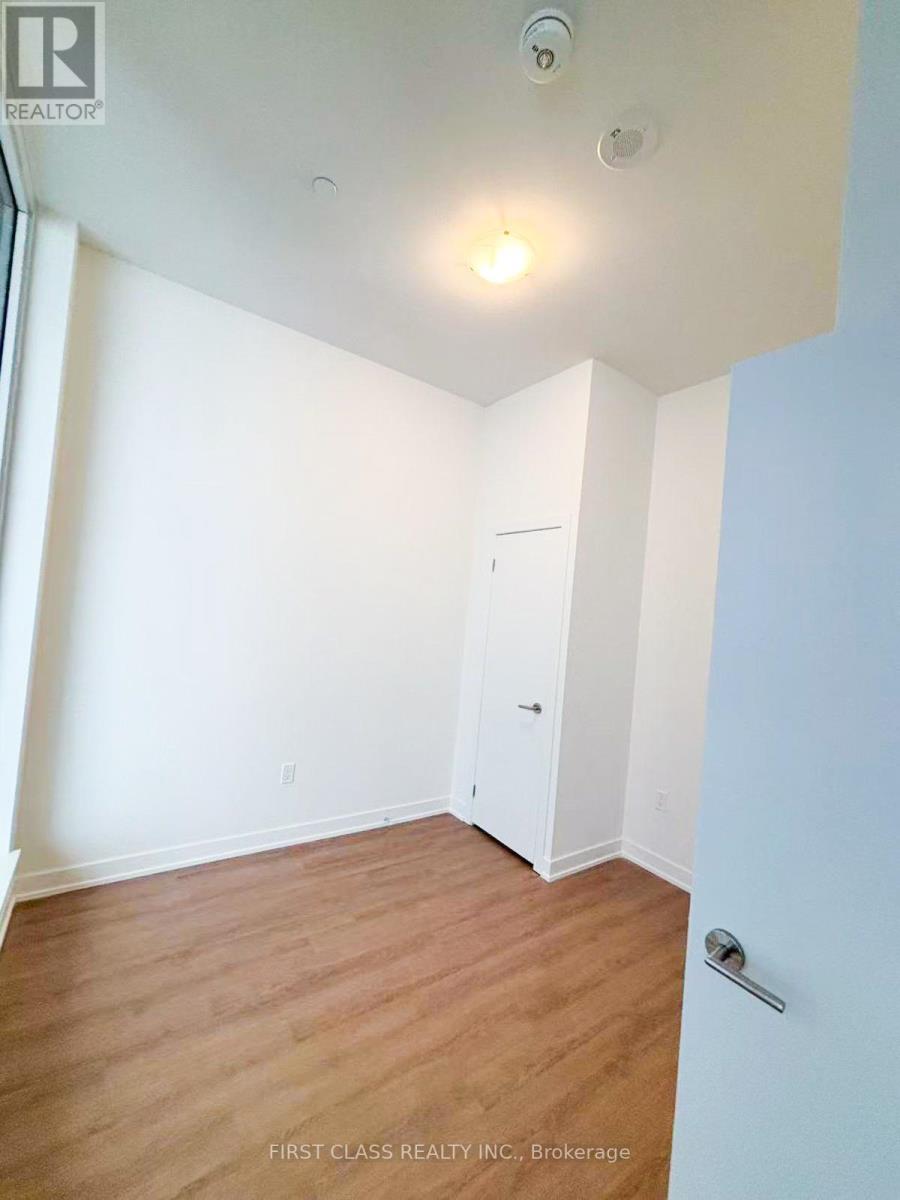 A room with a white door and a light on the ceiling.
