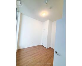 A room with a white door and a light on the ceiling.