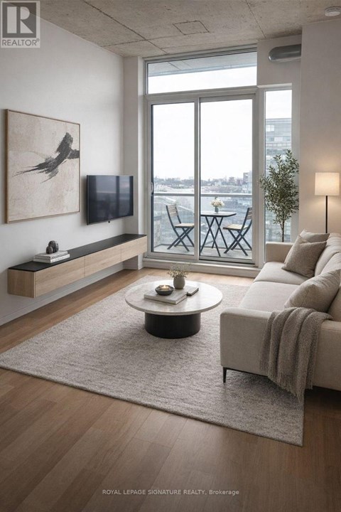 A living room with a couch, a coffee table, and a painting on the wall.