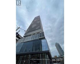 A tall building with a pointed top and a glass facade.