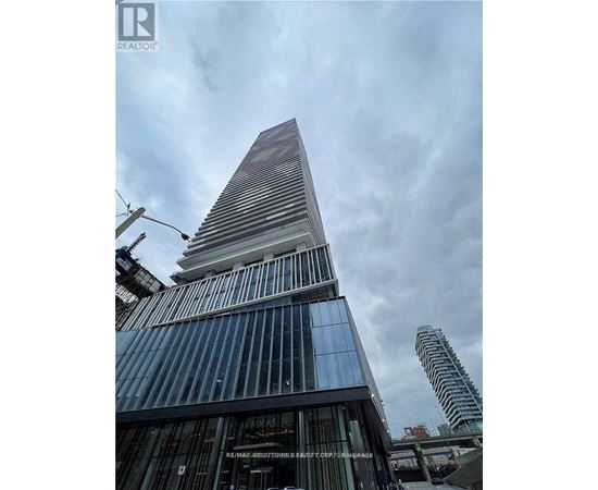 A tall building with a pointed top and a glass facade.