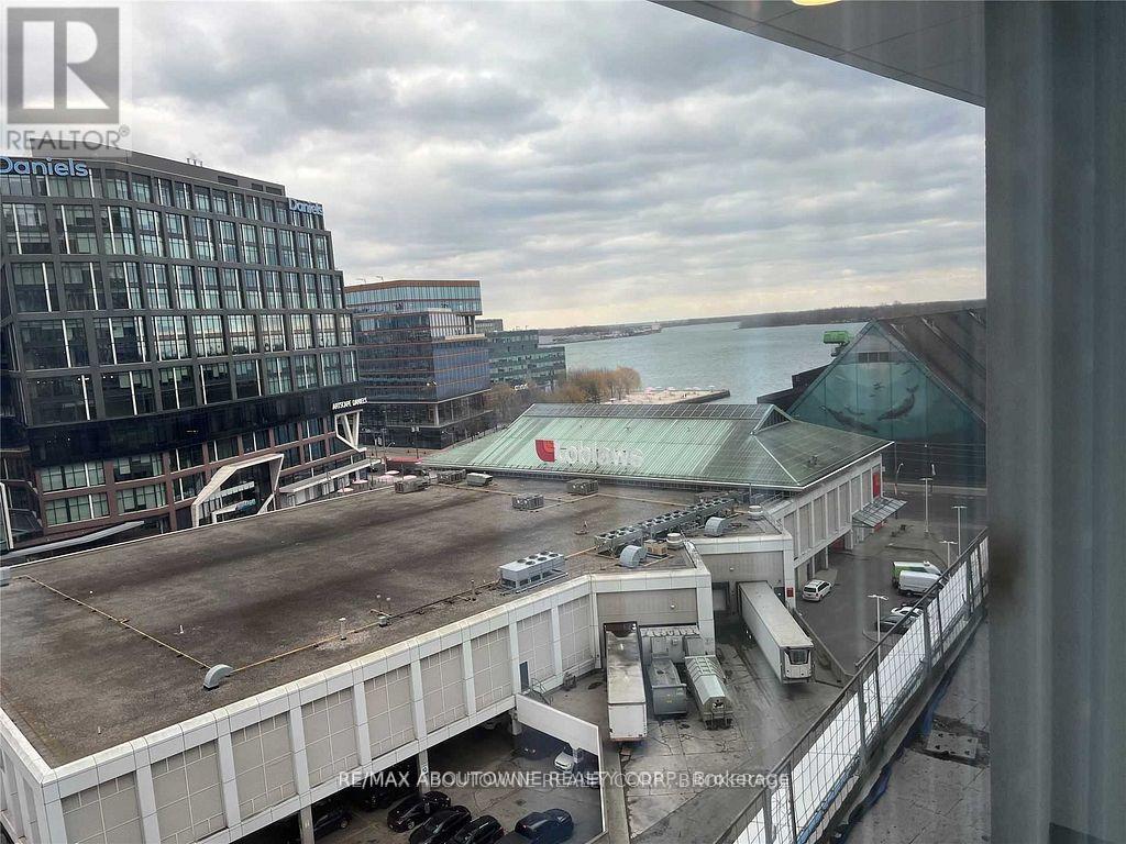 A view from a window of a parking lot and buildings.