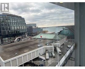 A view from a window of a parking lot and buildings.