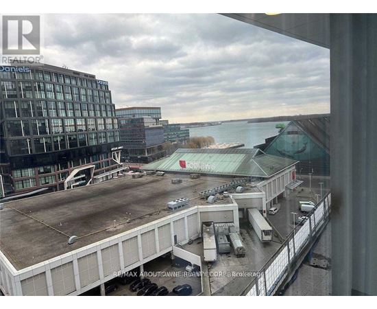 A view from a window of a parking lot and buildings.