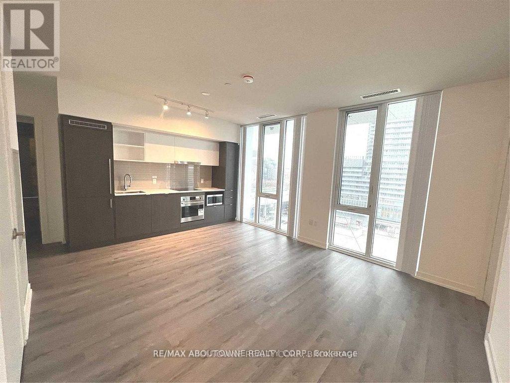 A spacious living room with hardwood floors and large windows.
