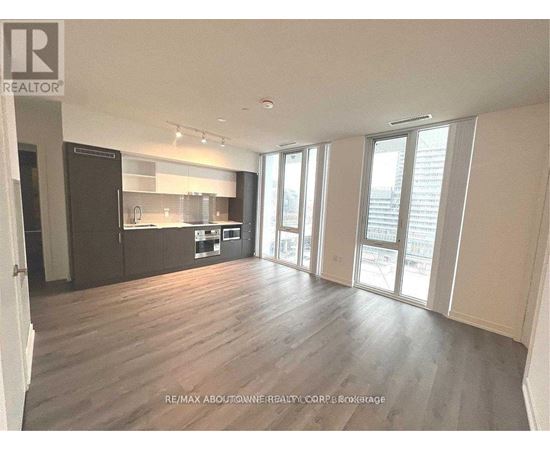 A spacious living room with hardwood floors and large windows.