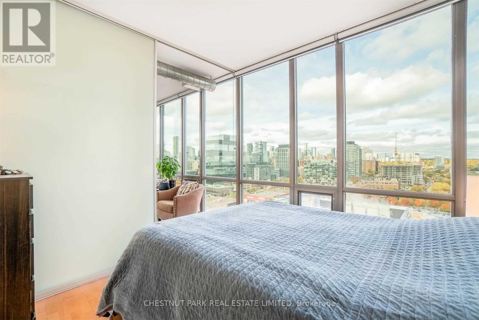 A bedroom with a large bed and a view of the city.