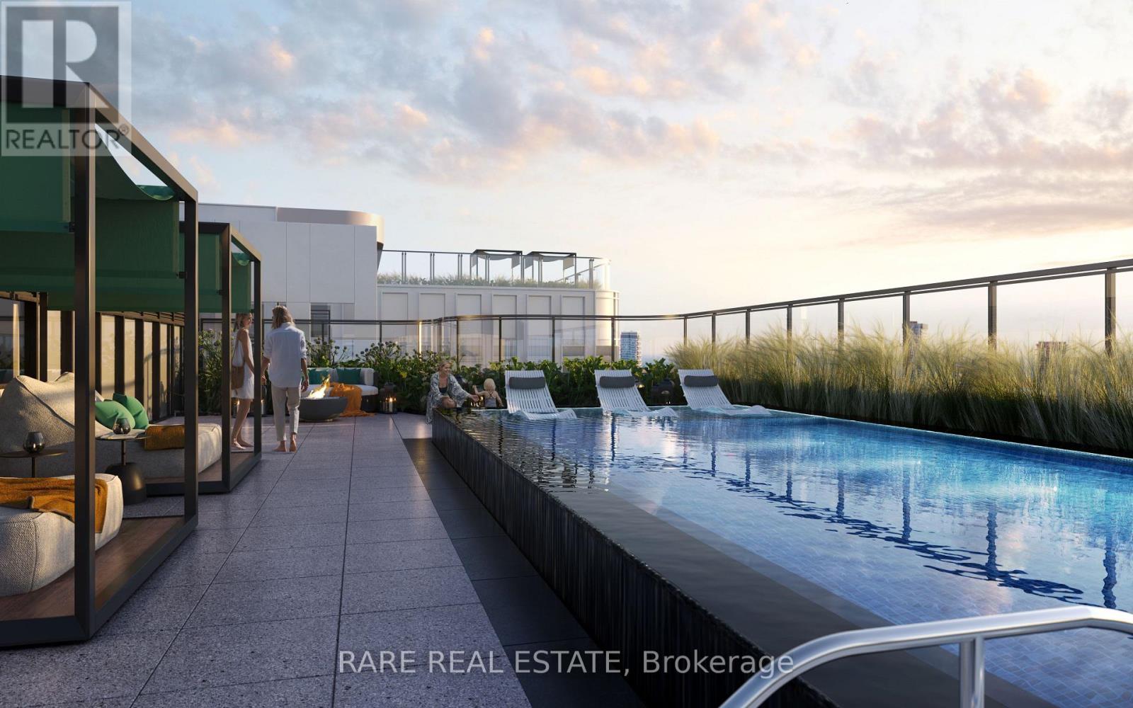 A pool area with a glass barrier and people standing by the pool.