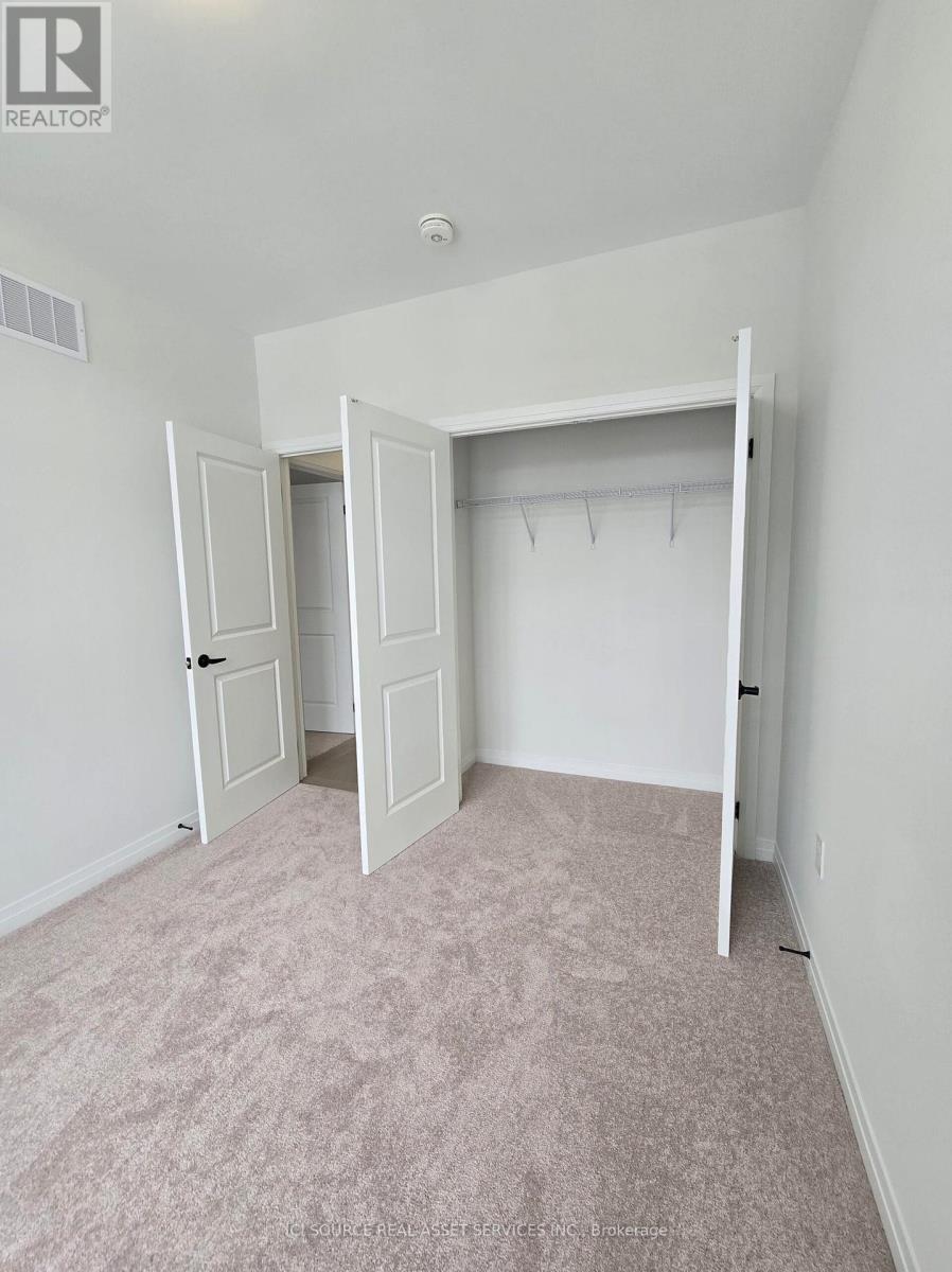 A bedroom with a carpeted floor and a closet with a white door.