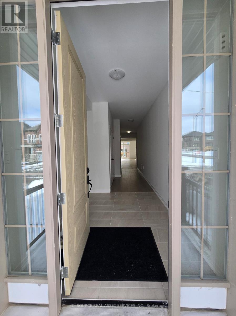 A hallway with a glass door and a black doormat.