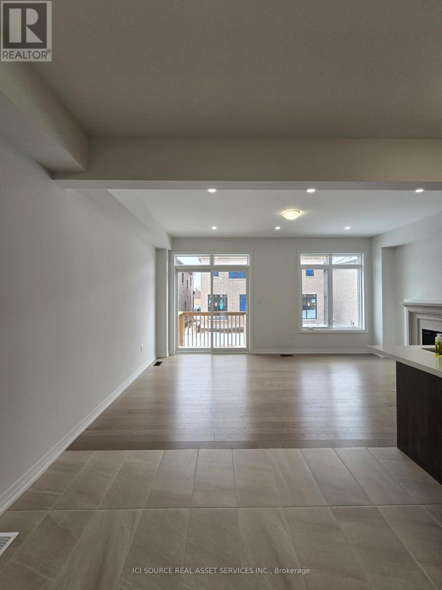 A spacious room with a tiled floor and a view of a balcony through the glass doors.