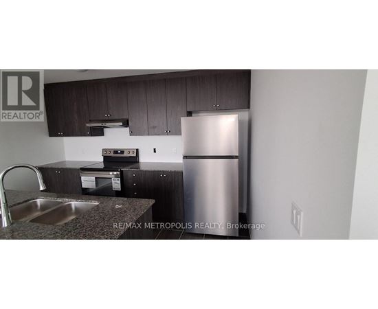 A kitchen with a stainless steel refrigerator and a sink.