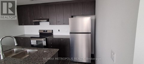 A kitchen with a stainless steel refrigerator and a sink.