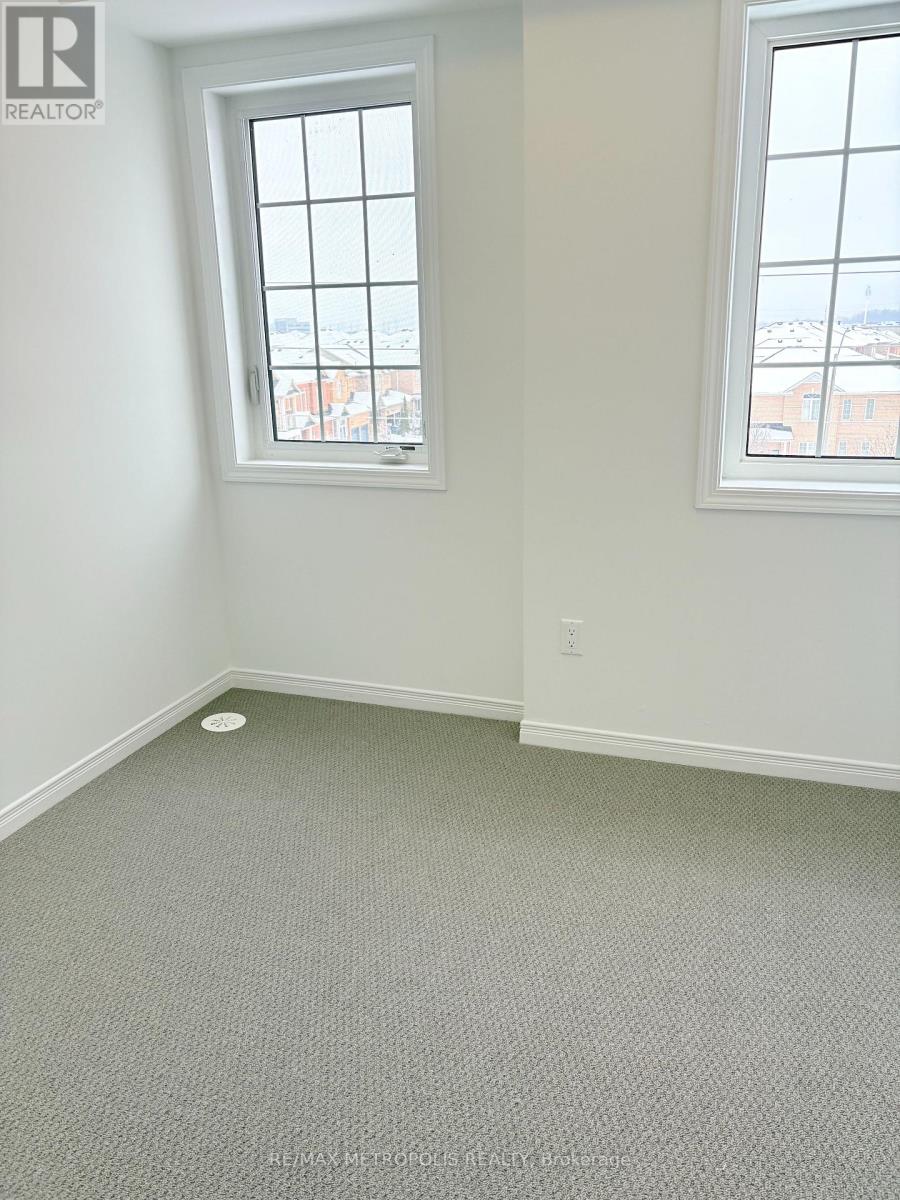 A room with a window and a grey carpet.