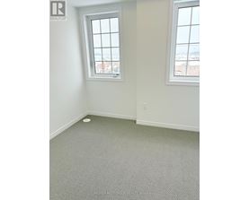 A room with a window and a grey carpet.