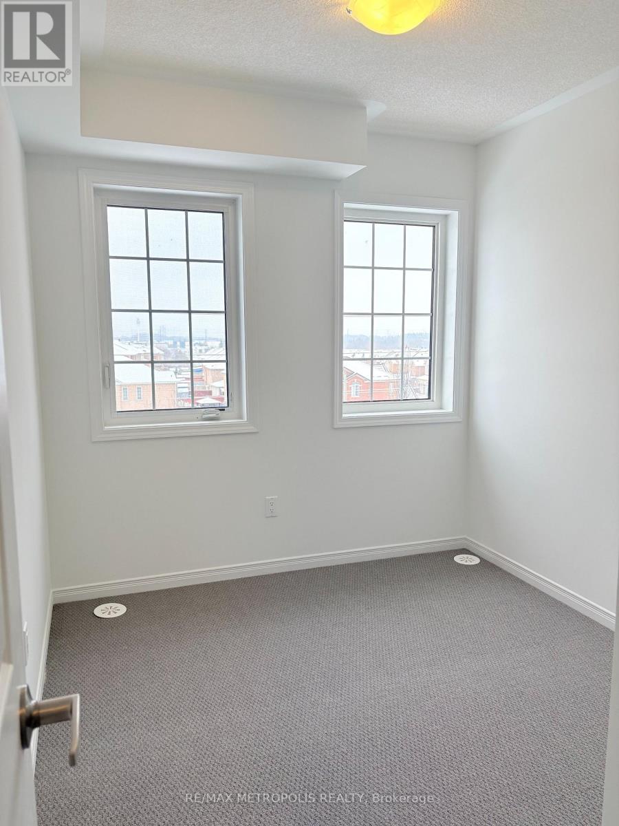 A room with a carpeted floor and two windows.