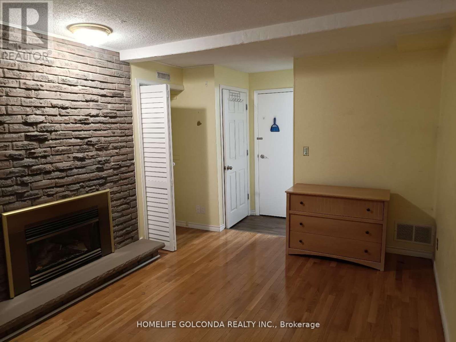 A room with a fireplace and a wooden floor.