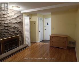 A room with a fireplace and a wooden floor.