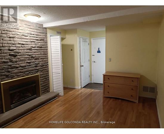 A room with a fireplace and a wooden floor.