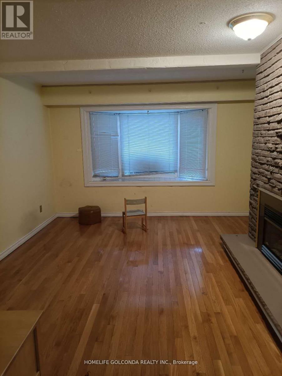 A room with wooden flooring and a window with blinds.