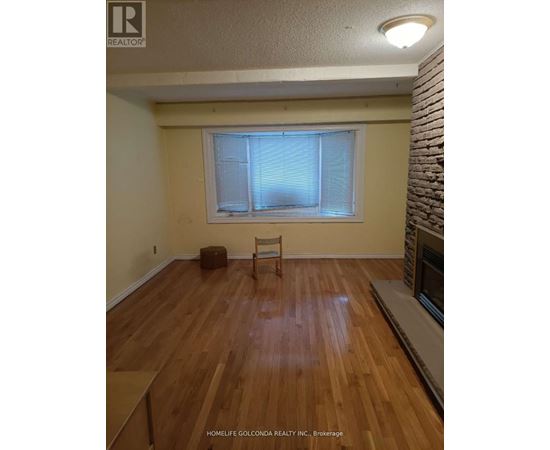 A room with wooden flooring and a window with blinds.