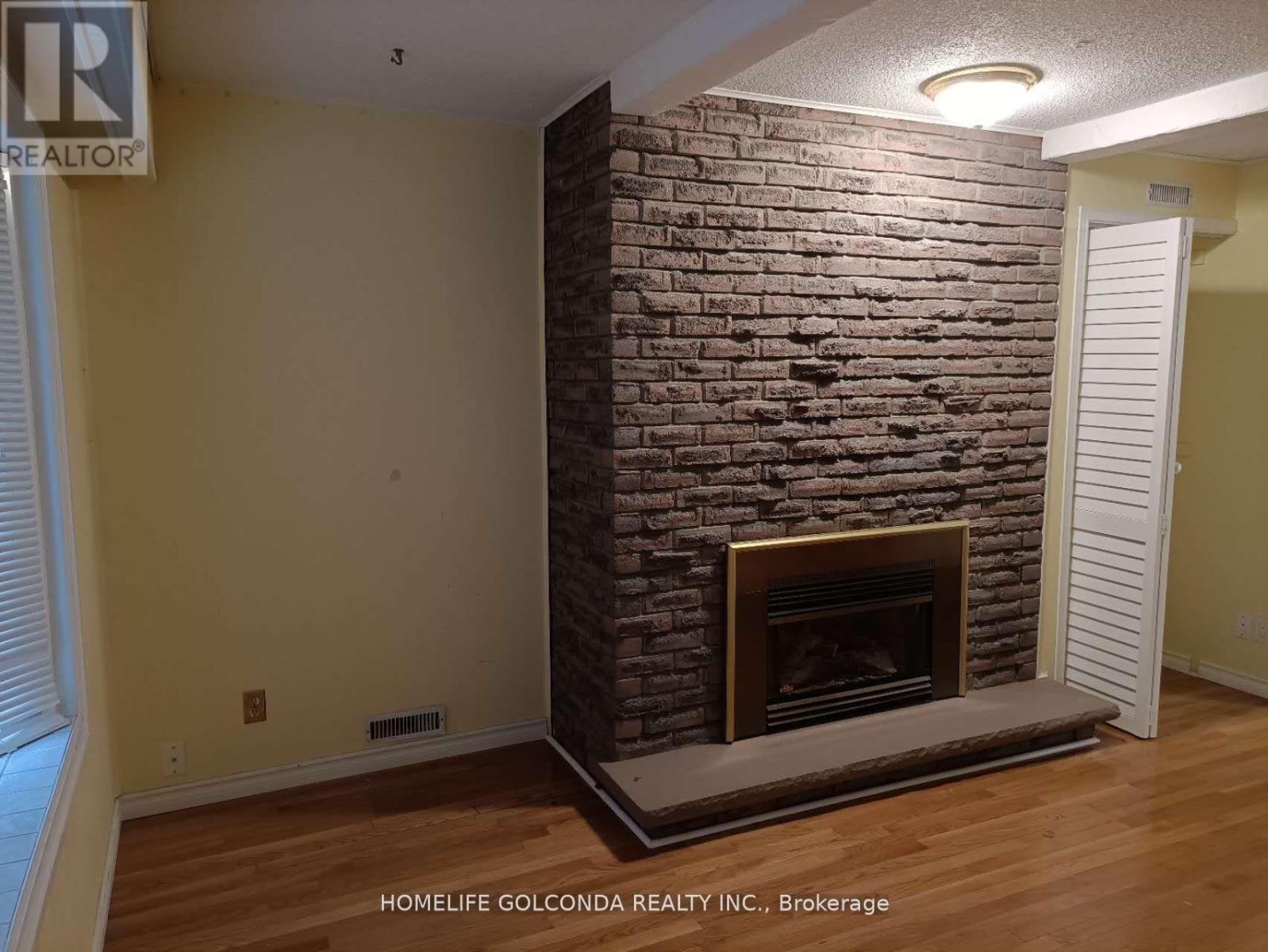 A room with a fireplace and a sign that says "REALTOR".