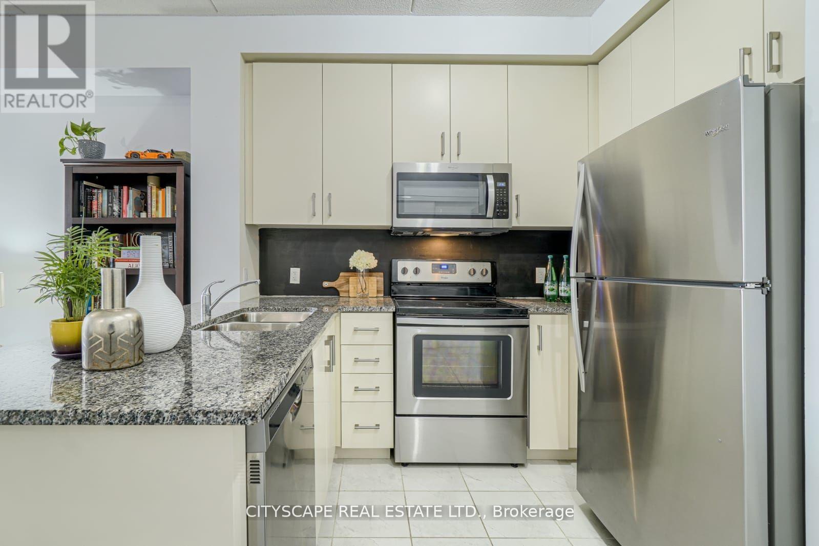 A kitchen with a refrigerator, microwave, and oven.