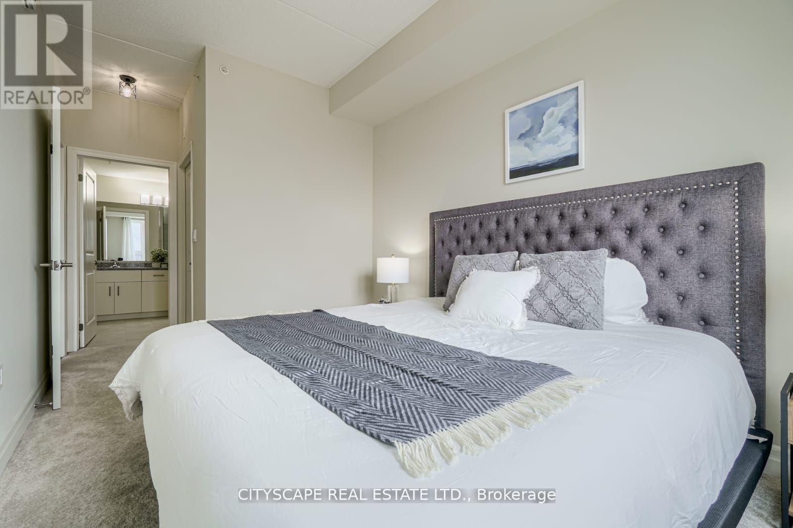 A bedroom with a large bed and a painting on the wall.