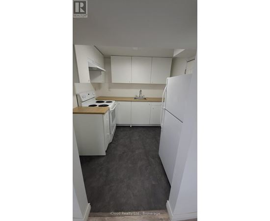 A kitchen with white appliances and cabinets.