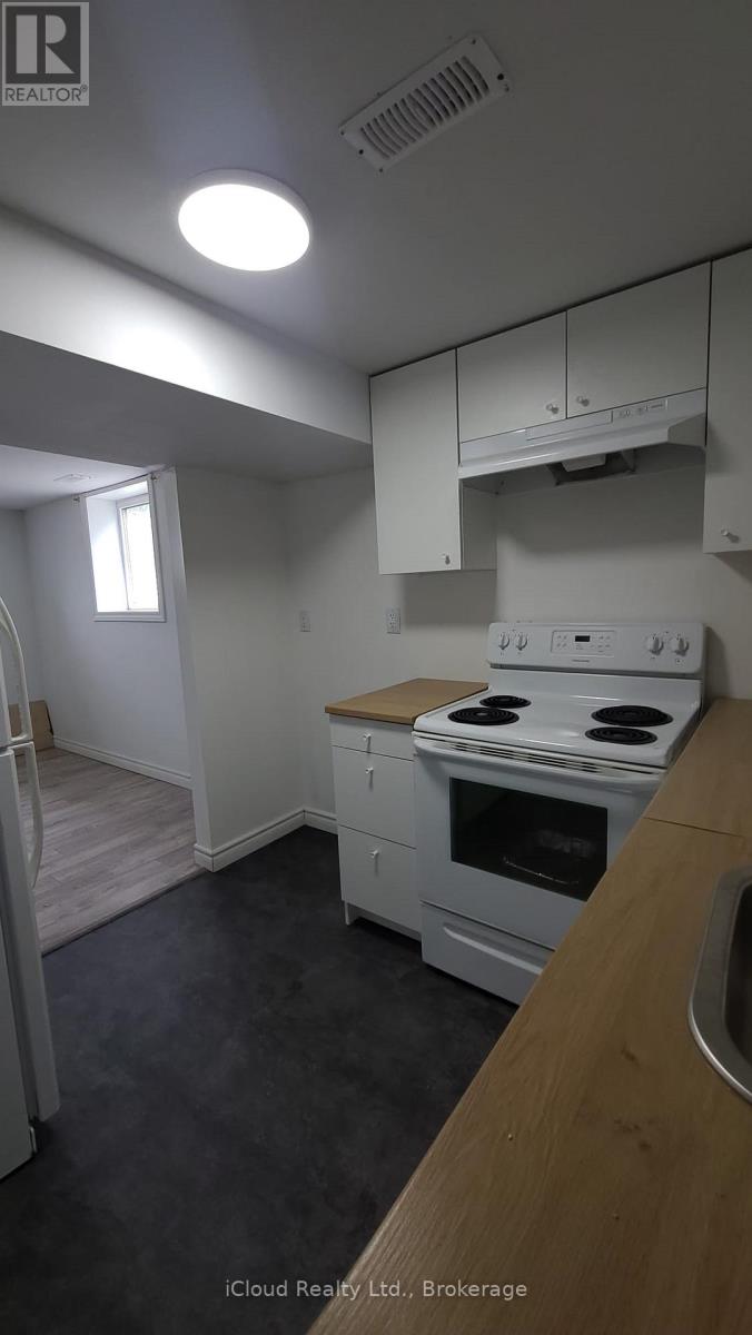 A kitchen with white appliances and a wooden counter.