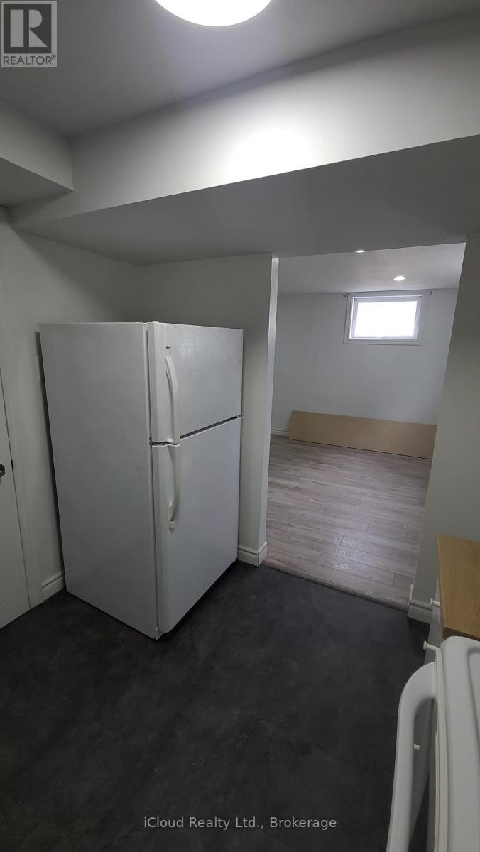 A white refrigerator in a room with a small window.