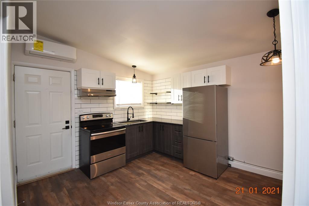 A kitchen with a stove top oven and a refrigerator.