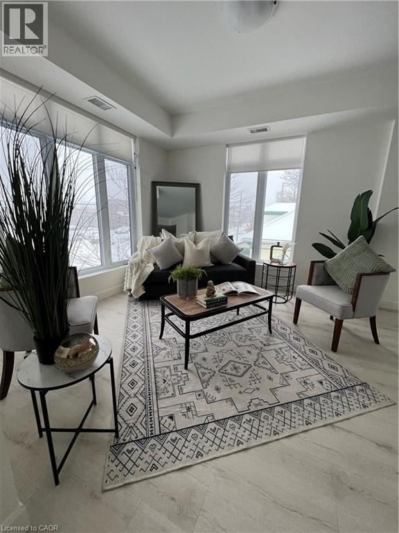 A living room with a rug, a coffee table, and a chair.