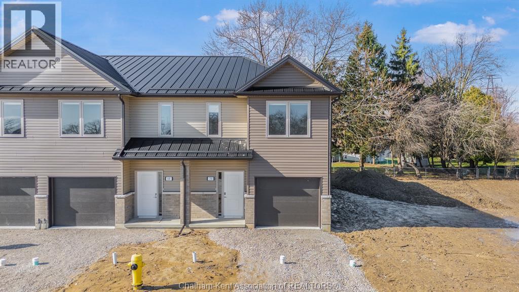 A house with a grey roof and a sign that says REALTOR on the left side.