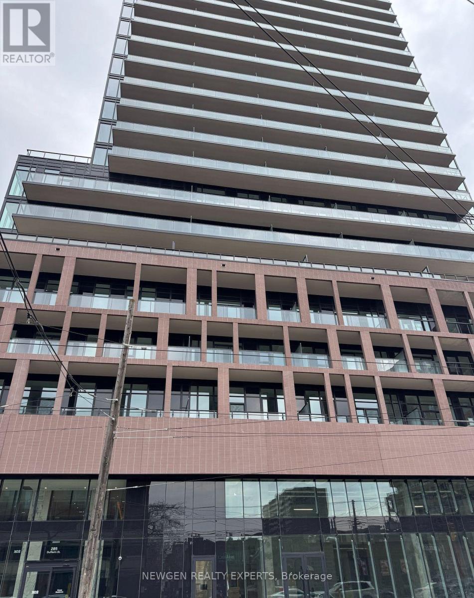 A tall building with a glass facade and a sign that reads "Newgen Realty Experts, Brokerage".