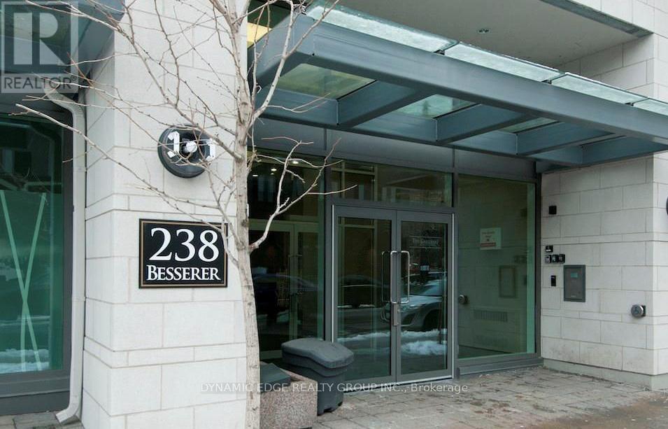 The entrance to a building with a glass door and a bench in front.