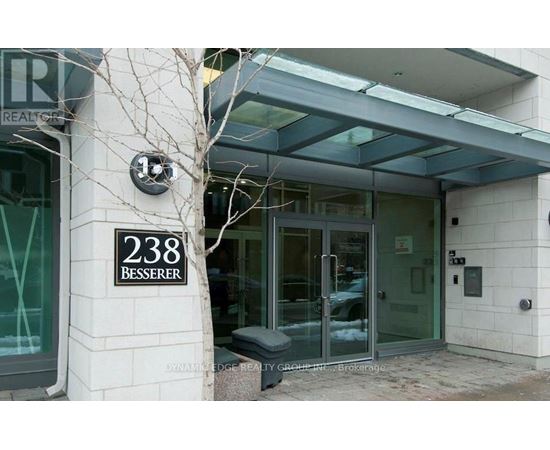 The entrance to a building with a glass door and a bench in front.