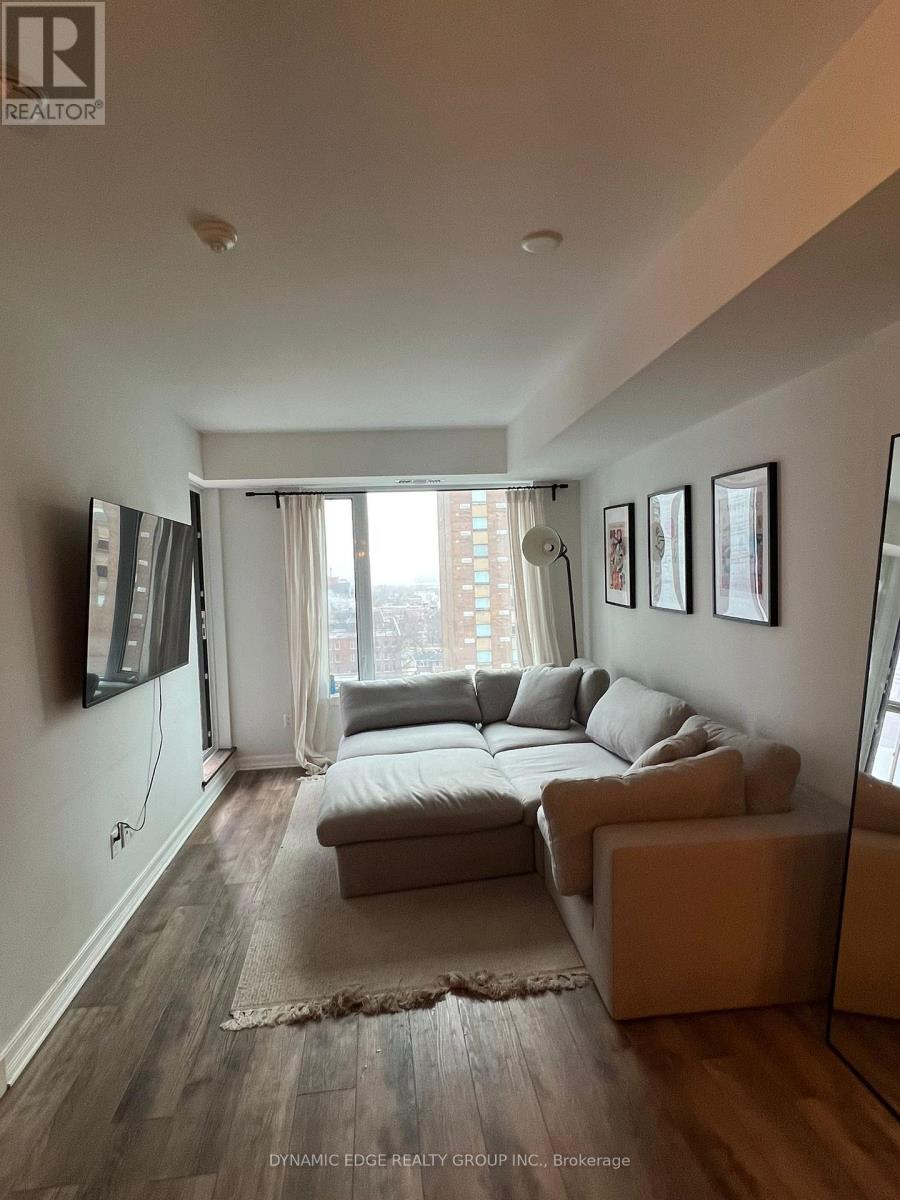 A living room with a couch, a rug, and a large window.
