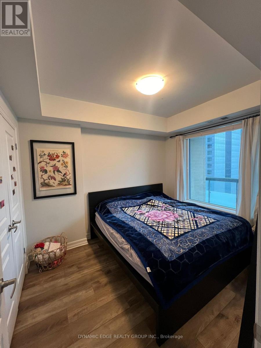 A bedroom with a bed and a framed picture on the wall.