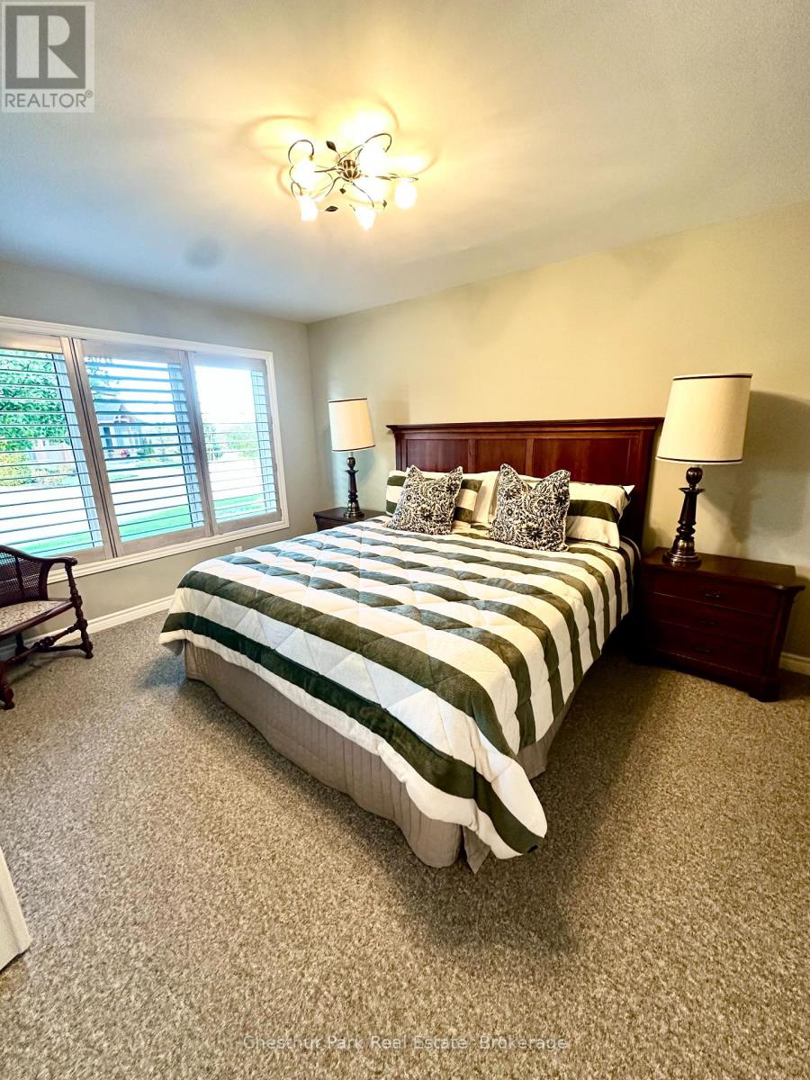 A bedroom with a bed, nightstands, and a window with blinds.