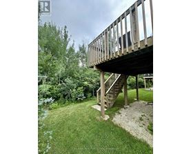 A wooden deck with a staircase leading to a gazebo.