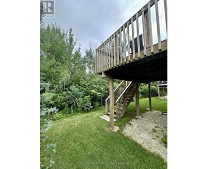 A wooden deck with a staircase leading to a gazebo.