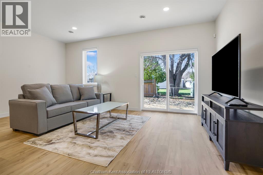 A living room with a grey couch, a coffee table, and a flat screen TV.